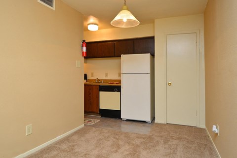 a small kitchen with a white refrigerator and a door
