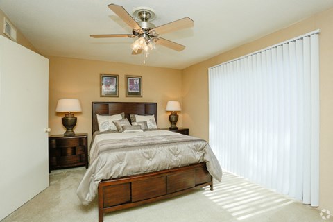 a bedroom with a large bed and a ceiling fan