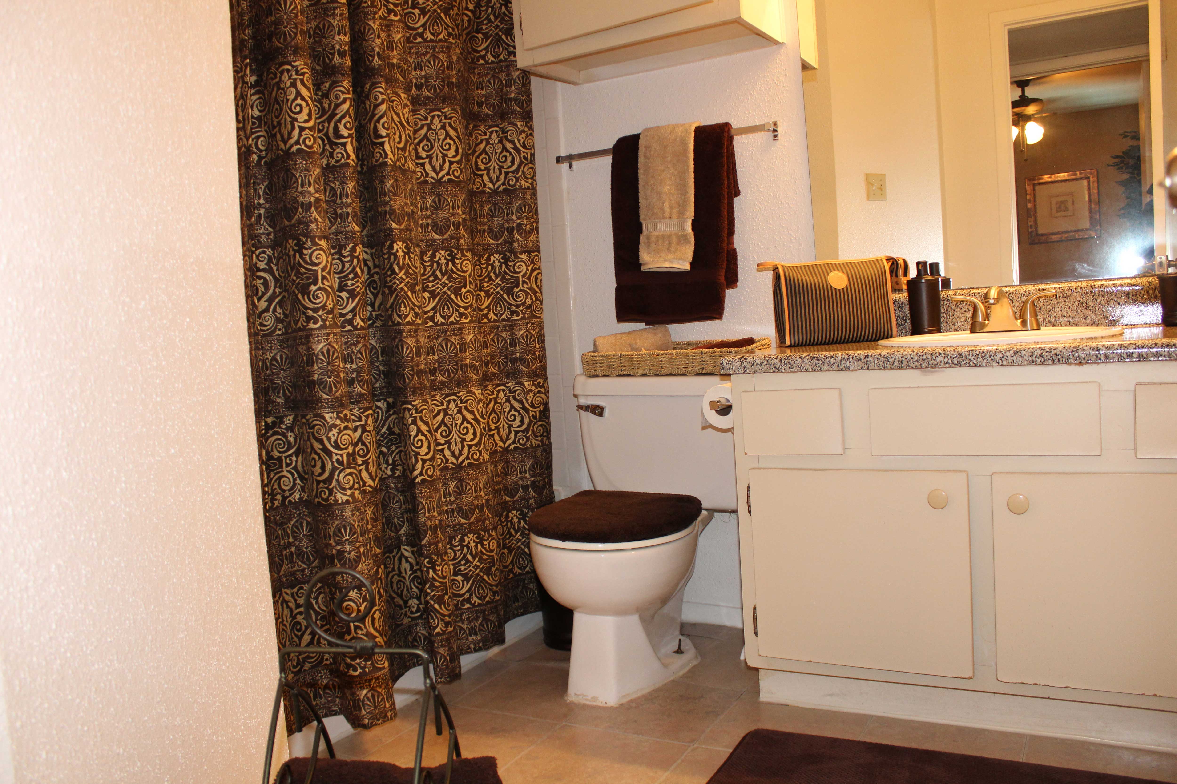 a bathroom with a toilet and a shower curtain