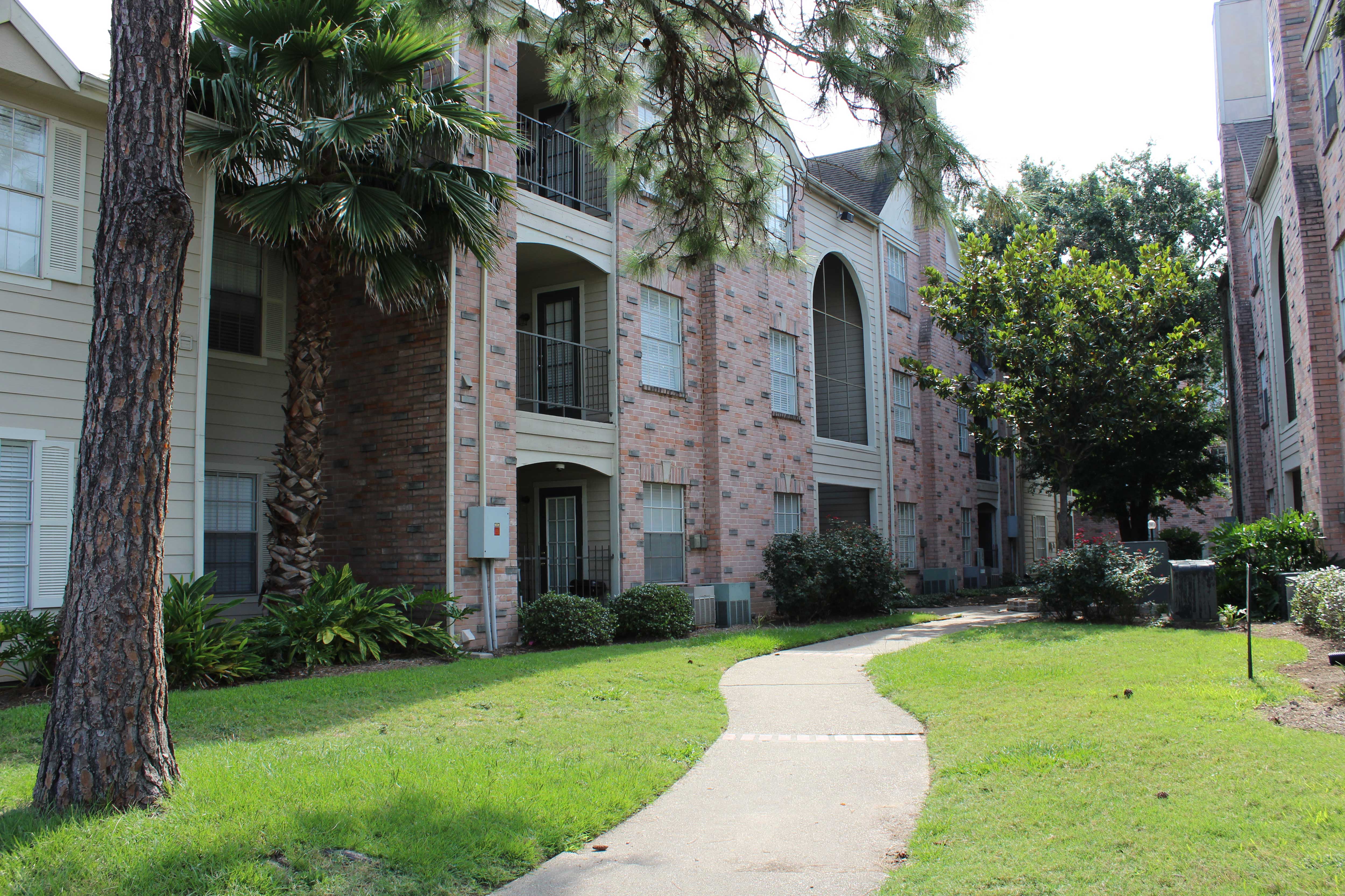 a walkway in front of an apartment building