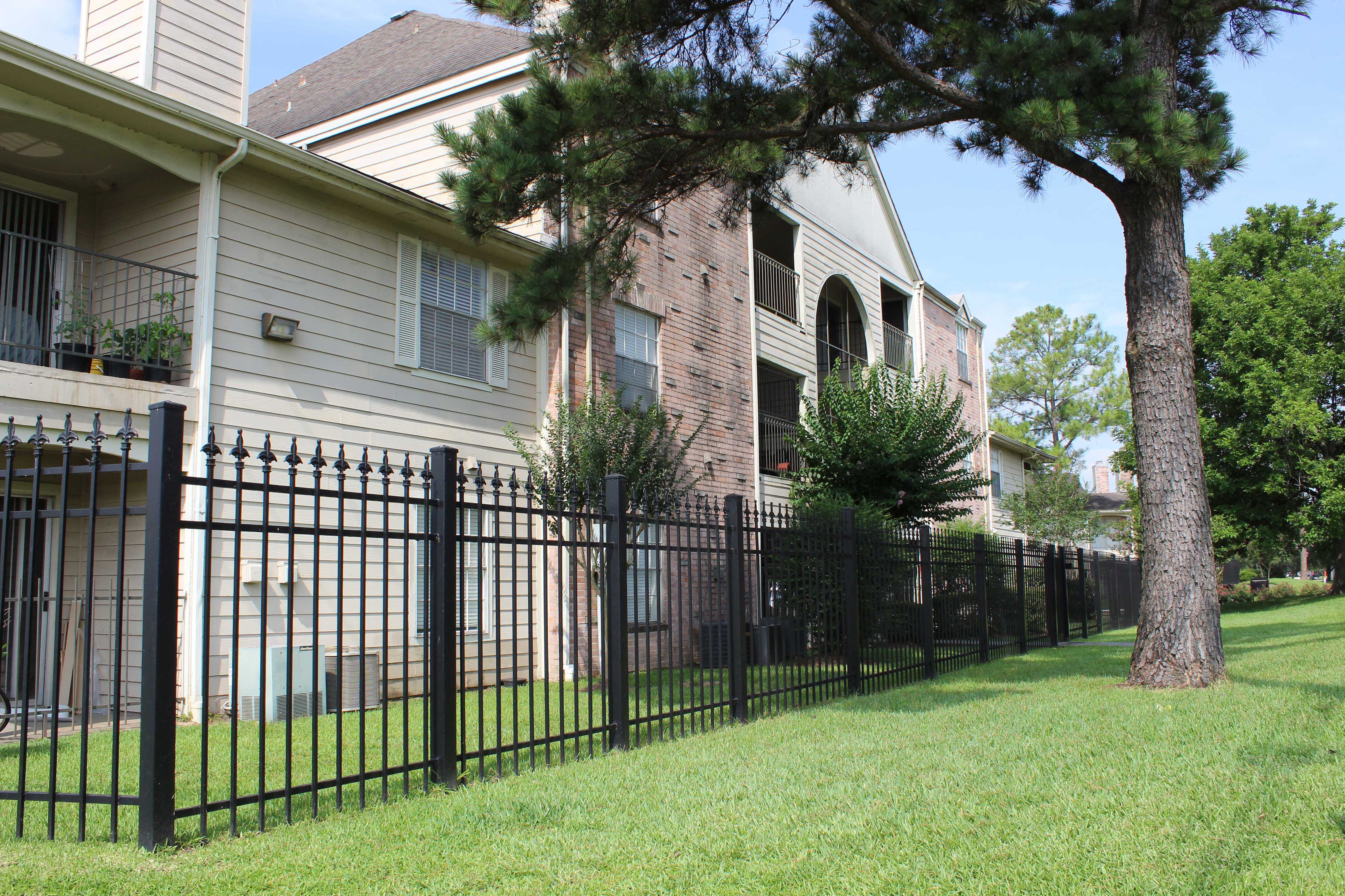 a house with a wrought iron fence in front of a yard