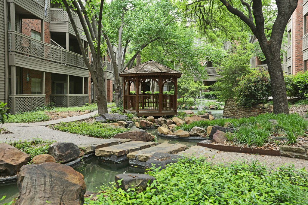 a garden with a gazebo in the middle of a courtyard