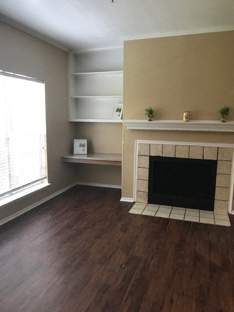 a living room with a fireplace and wooden floors