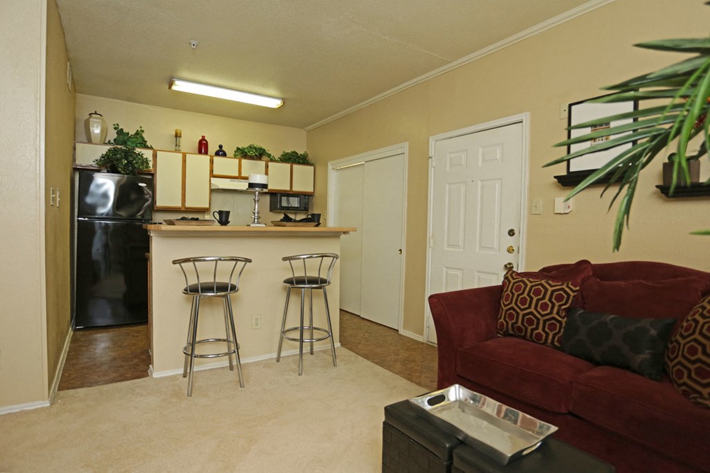 a living room and kitchen with a couch and a bar