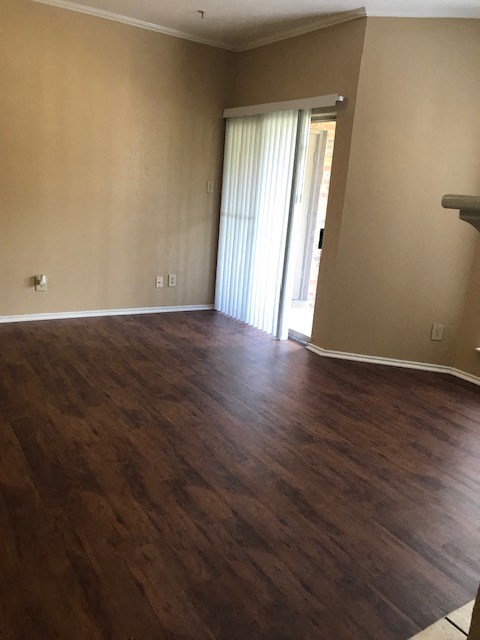 an empty living room with a wood floor and a door