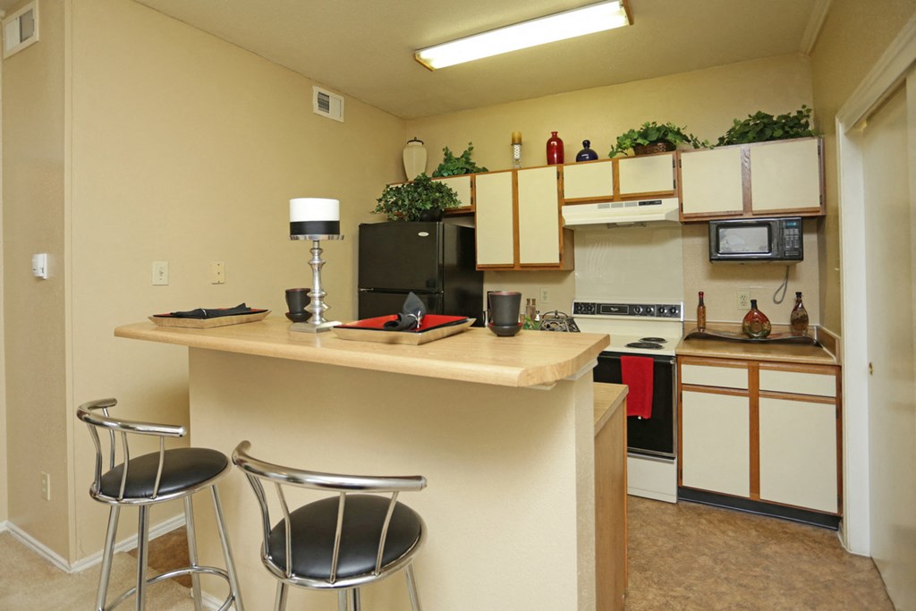 a kitchen with a breakfast bar and a counter top with two stools