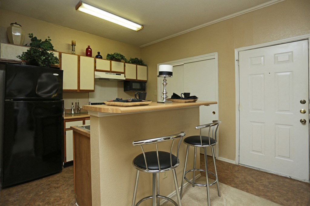 a kitchen with a counter and two stools