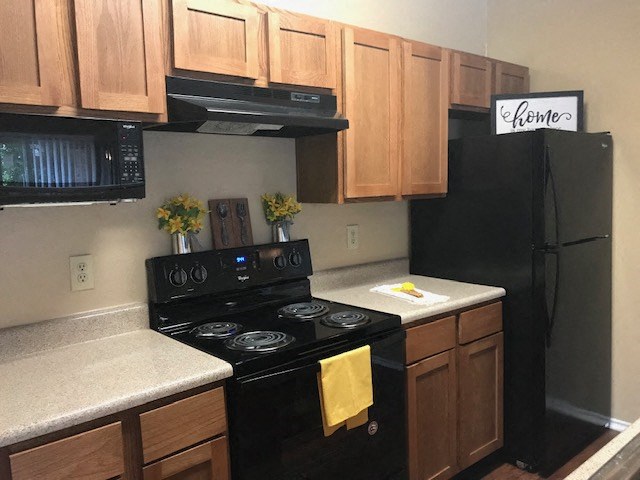a kitchen with black appliances and wooden cabinets