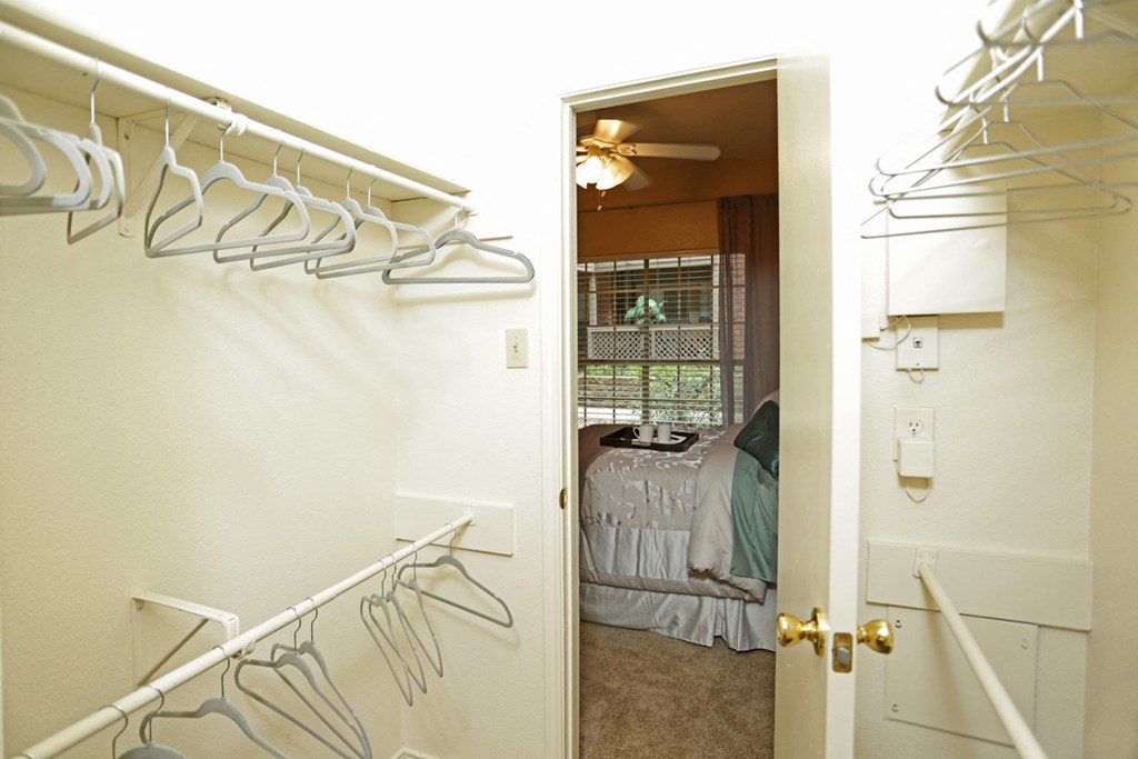 a bedroom with a closet and hangers on the closet door