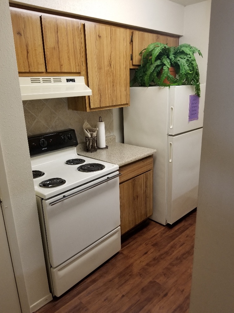 a kitchen with white appliances and a refrigerator