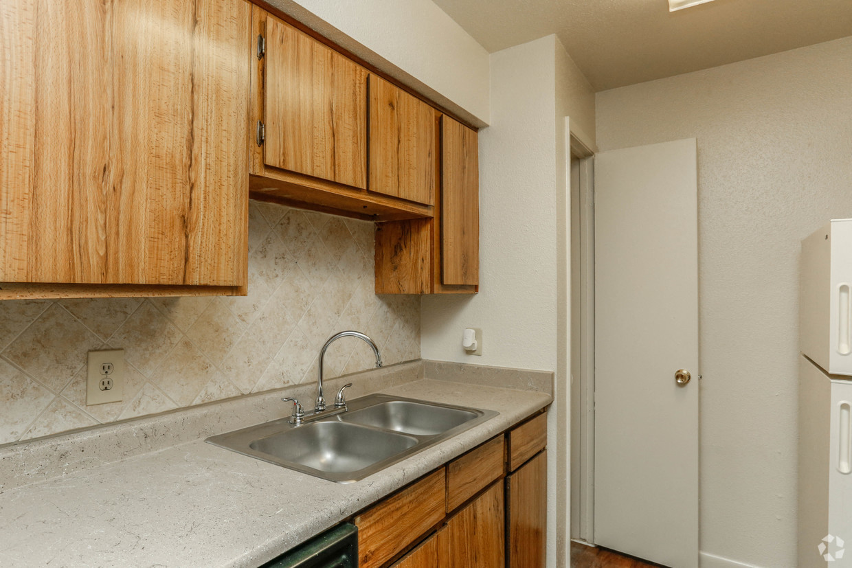 a kitchen with a sink and wooden cabinets