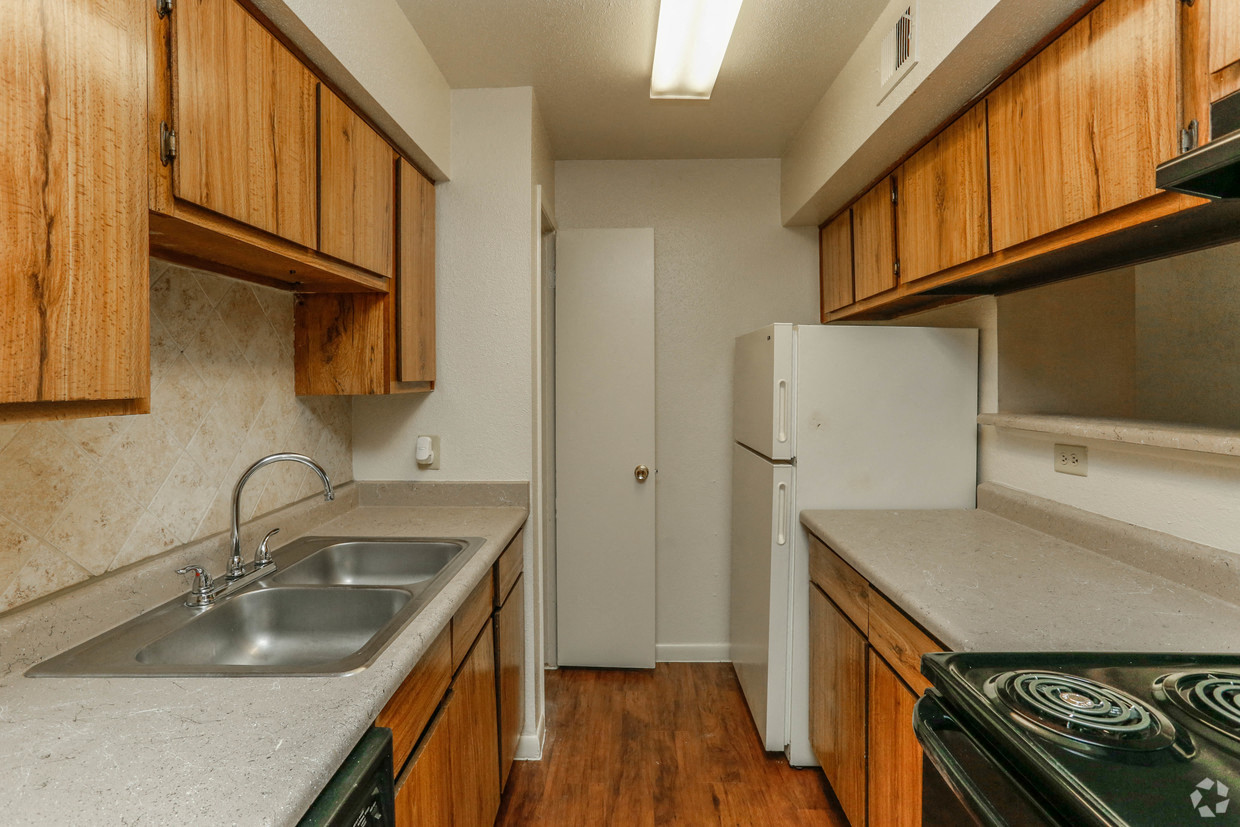 a kitchen with wooden cabinets and a sink and a refrigerator