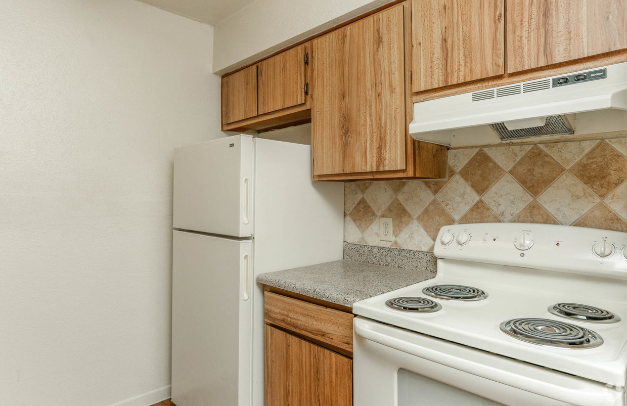 a kitchen with a white stove and refrigerator