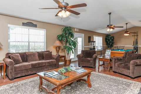 a living room with couches and a table and a ceiling fan