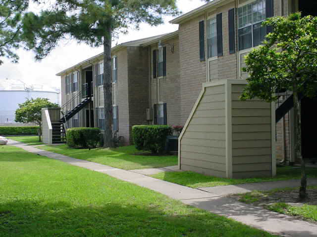 an apartment building with a sidewalk and a staircase
