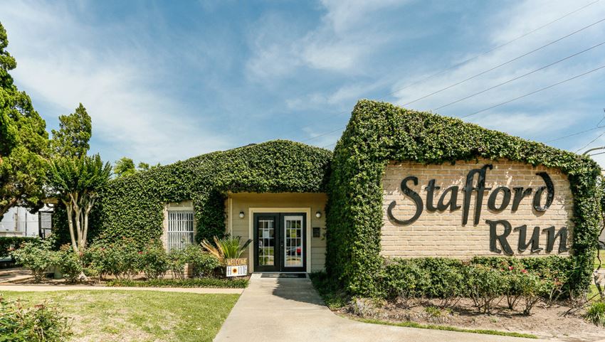 the sign for station run in front of a building with ivy on it