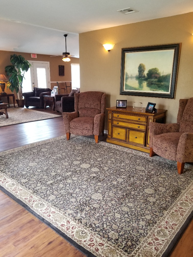 a living room with chairs and a rug
