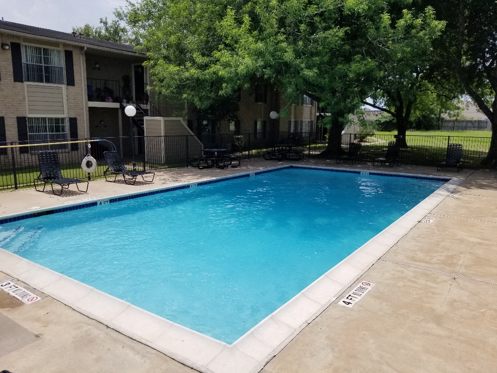 a swimming pool in front of a apartment building
