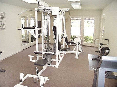 a gym with a lot of machines and chairs in it