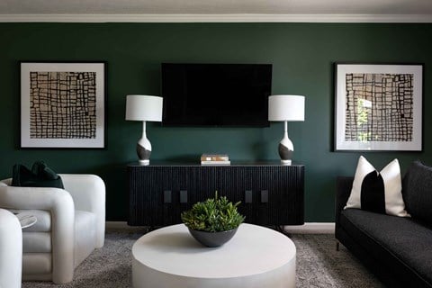 a living room with green walls and a white coffee table