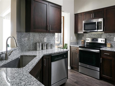 a kitchen with granite counter tops and stainless steel appliances