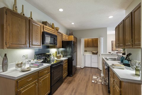 a kitchen with black appliances and wooden cabinets