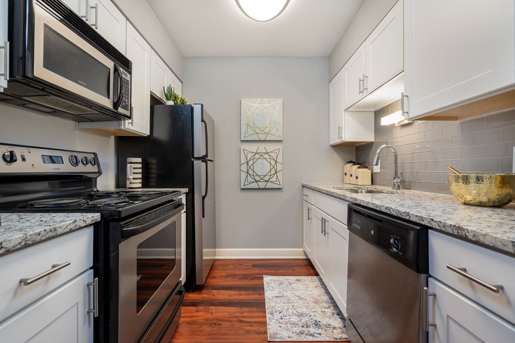 a kitchen with stainless steel appliances and marble counter tops