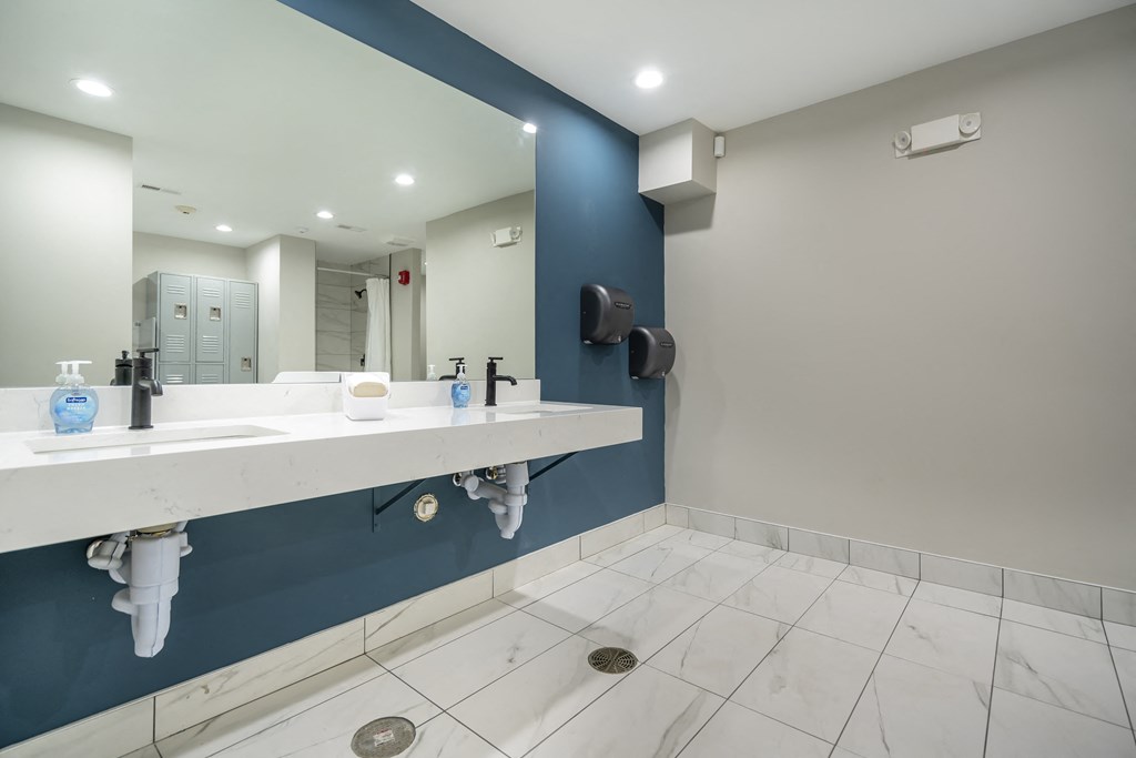 a public bathroom with two sinks and a mirror