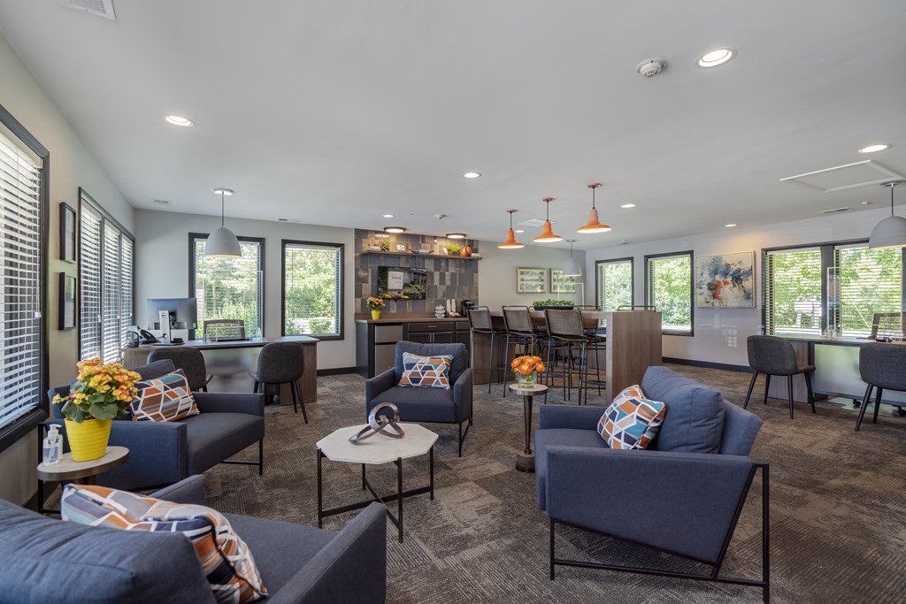 a living room with blue couches and chairs and a bar