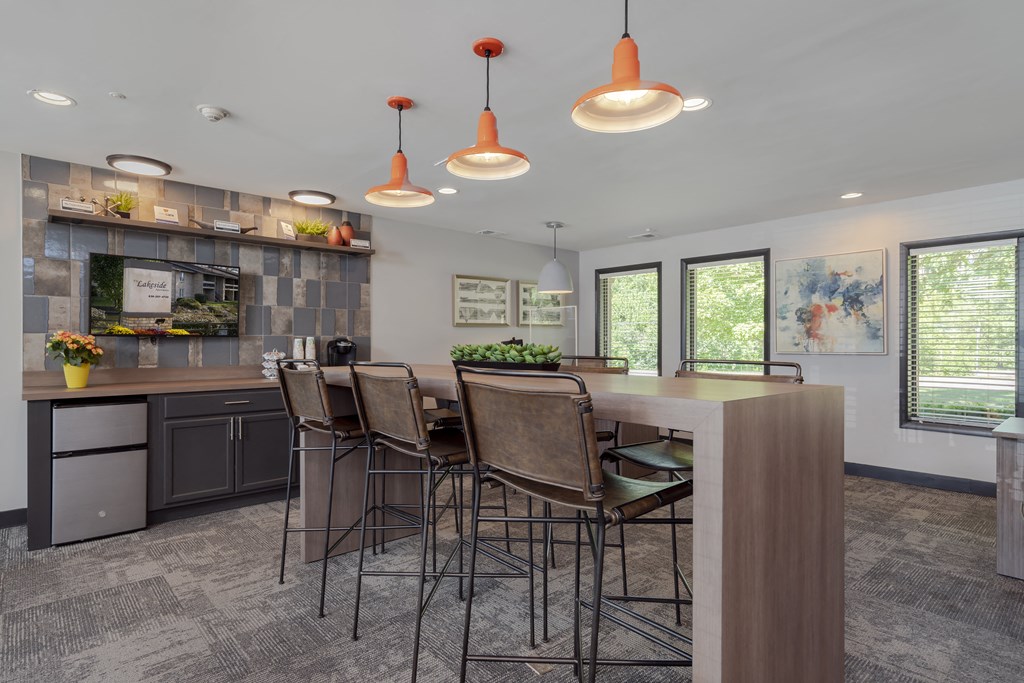a kitchen with a bar and chairs in a house