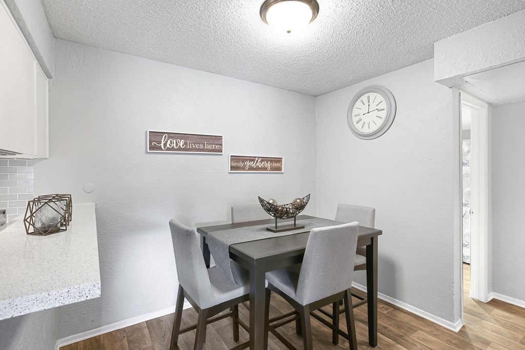 a dining room with a table and chairs and a clock on the wall