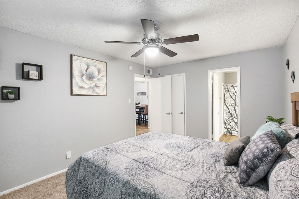 a bedroom with a large bed and a ceiling fan