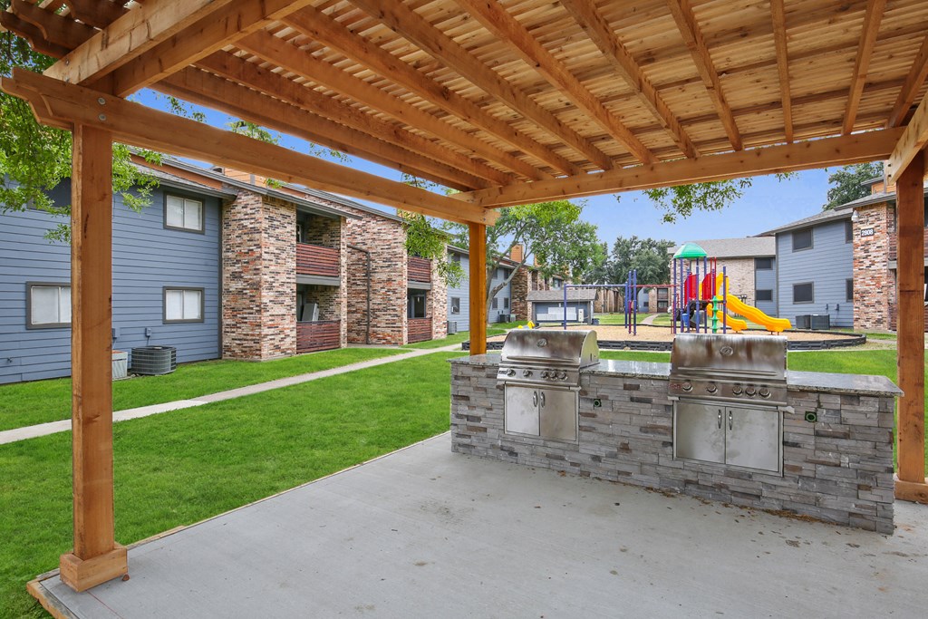 the backyard has a patio with a grill and a playground