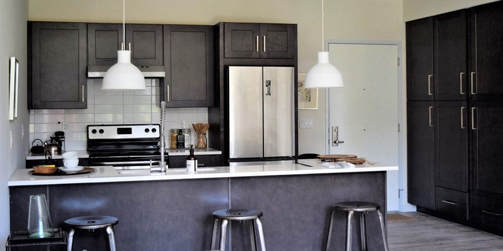 a kitchen with black cabinets and a white counter top