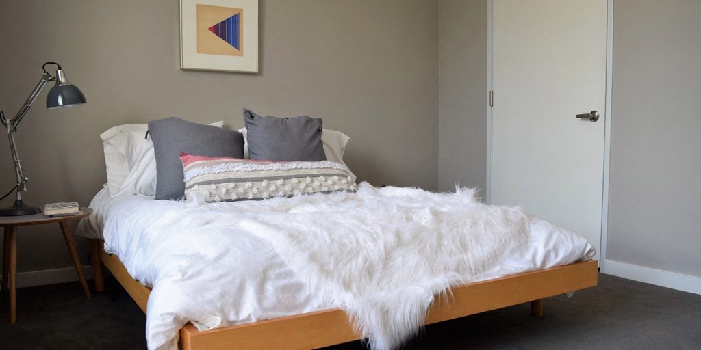 a bed with a white blanket and pillows on it