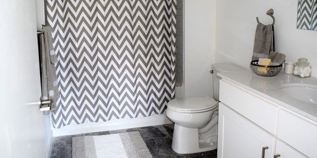 a bathroom with a toilet and a shower curtain