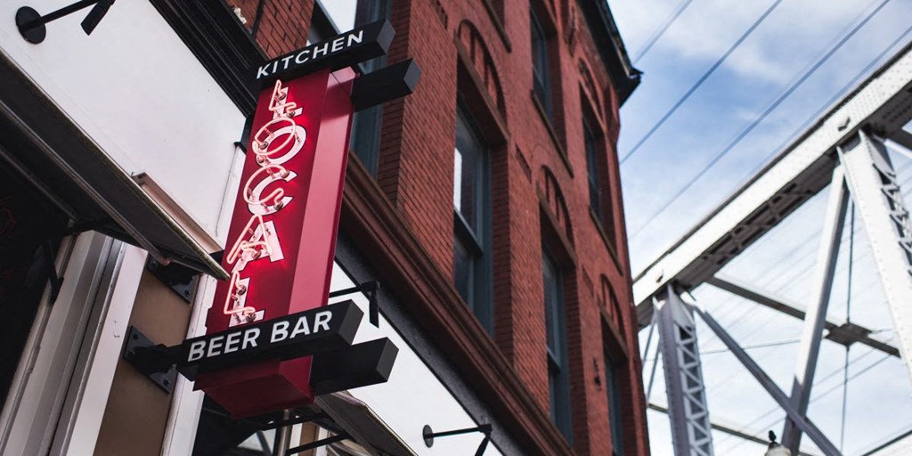a beer bar sign on the side of a building