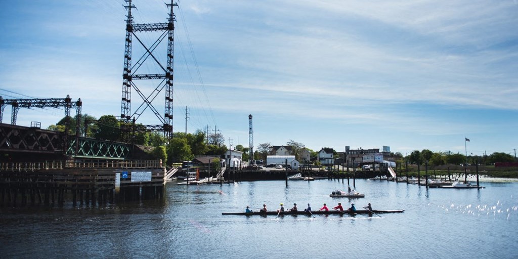 a group of people in kayaks on the water in a harbor