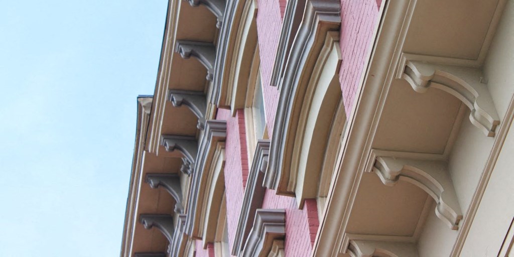 a building with a pink facade and a blue sky