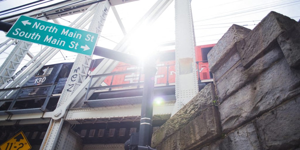 a street sign for south main street under a bridge