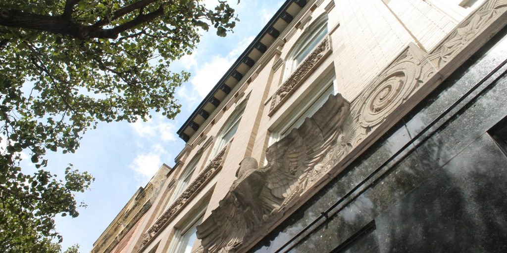 the facade of a building with an eagle sculpture on the side of it