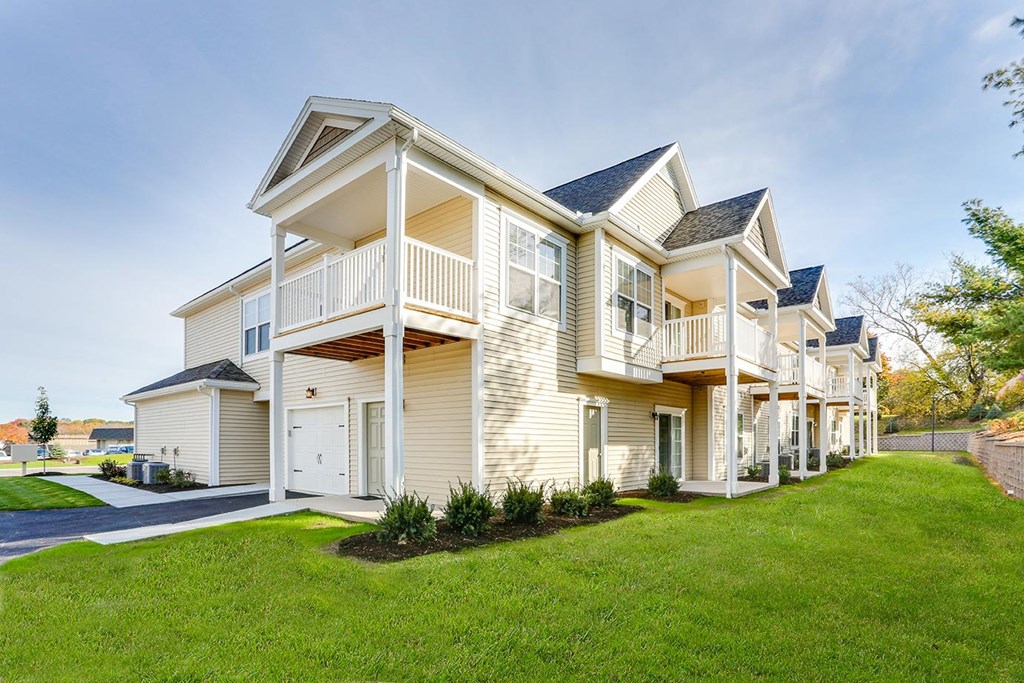 a large yellow house with a yard in front of it