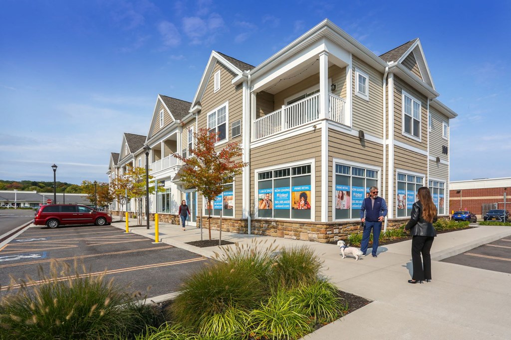 people standing outside of a building with a dog