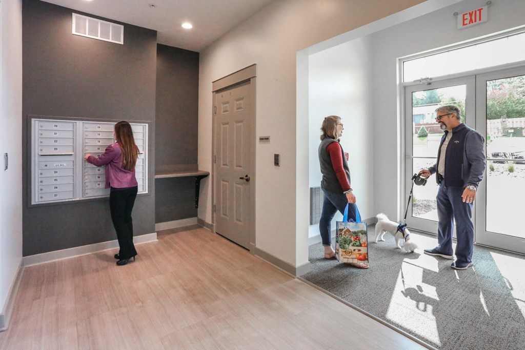 people standing in the lobby of a building with a dog