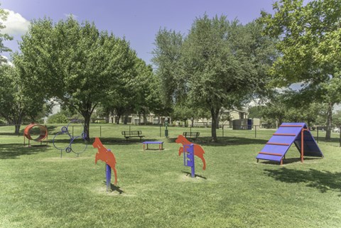 A playground with a slide, swings, and a seesaw.
