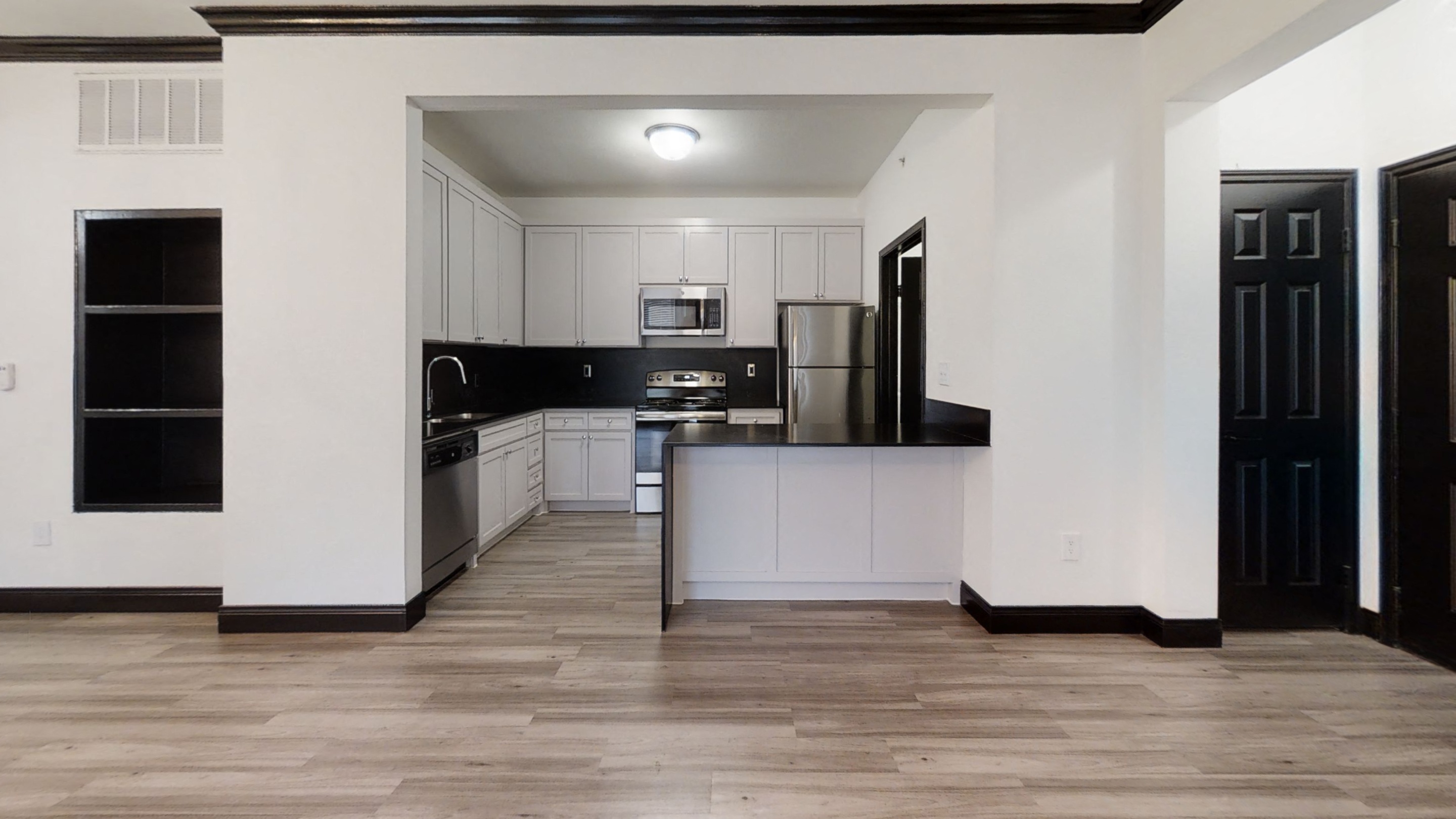 Spacious Living Room with Wood Style Flooring and Renovated Kitchen with Stainless Steel Appliances