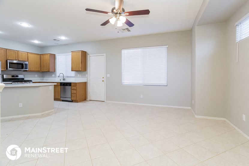 an empty kitchen with a ceiling fan and a white tile floor