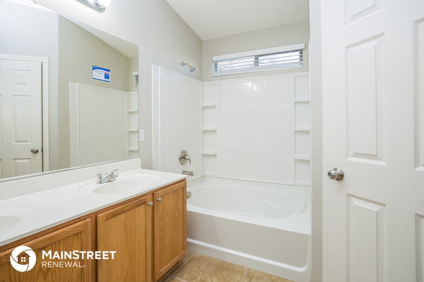 a bathroom with a tub and a sink and a mirror