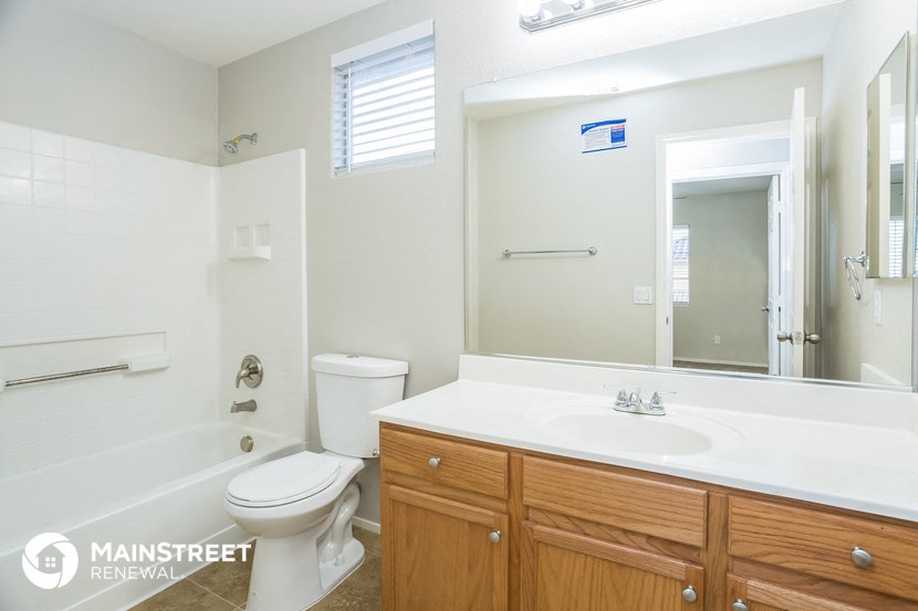 a bathroom with a large mirror and a sink and a toilet