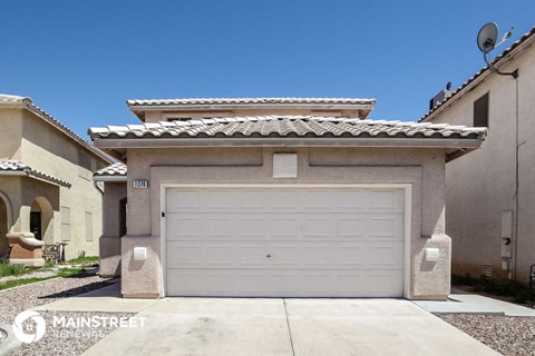 a white garage door on a tan house with a tile roof